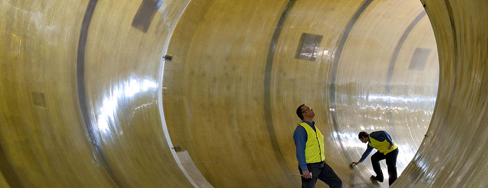 A large composite pipe section being inspected after manufacture